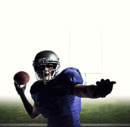 Sportsman playing football against american football postsの写真素材