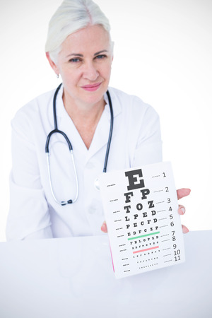Portrait of smiling female doctor showing notepad against eye testの写真素材