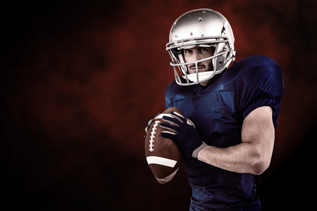 Sportsman ready to throwing the ball against dark backgroundの写真素材