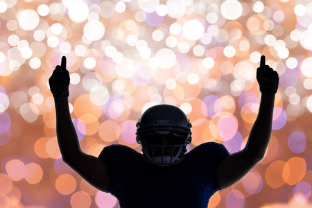 Silhouette American football player with thumbs up against glowing background