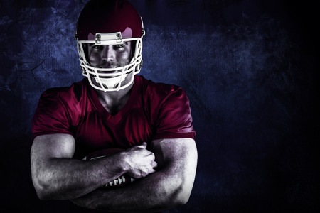 American football player with ball against dark backgroundの写真素材