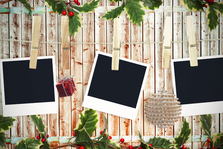 Christmas photos on a line against wooden background in pale woodの写真素材