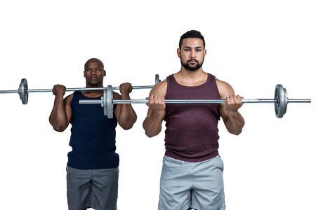 Man lifting barbell with trainer on white backgroundの写真素材