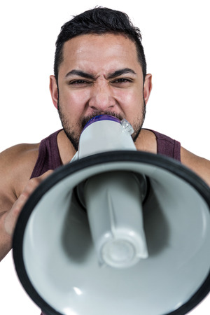 Muscular man yelling through a megaphone against white backgroundの写真素材