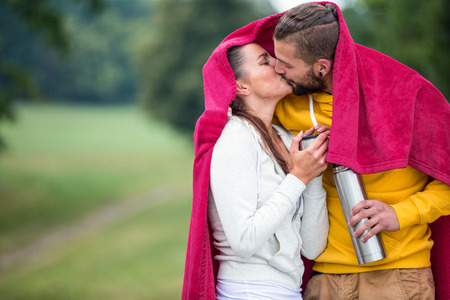 Happy couple under a blanket in the countrysideの写真素材