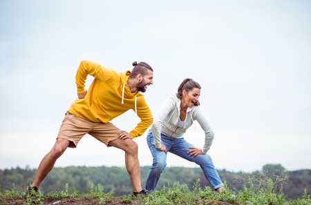 Couple stretching on a hike in the countryside