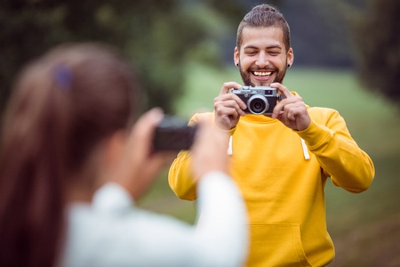 Happy couple taking photos of each other in the countrysideの写真素材