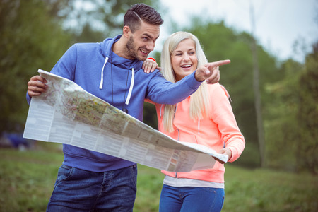 Happy couple reading a map together in the countrysideの写真素材