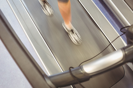 Fit woman jogging on treadmill at the gymの写真素材