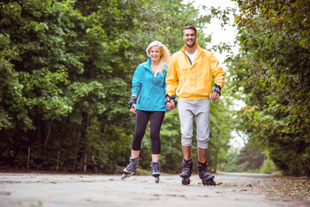 Happy couple roller blading together in the countrysideの写真素材