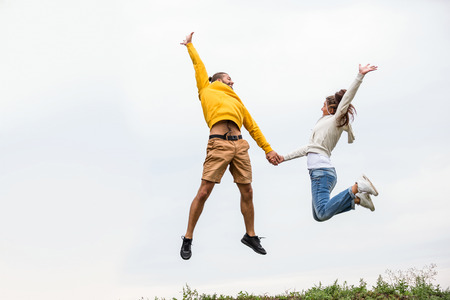 Couple jumping on a hike in the countrysideの写真素材