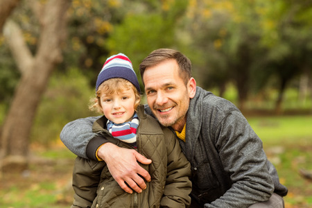 Happy father posing with his son on an autumns day