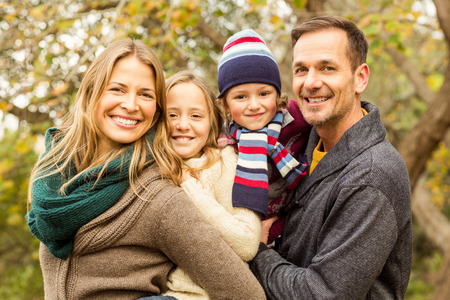 Smiling young family posing together on an autumns dayの写真素材