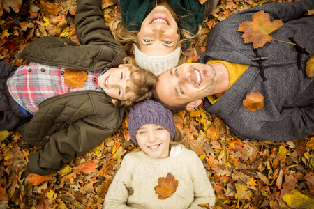 Smiling young family doing a head circles on an autumns dayの写真素材