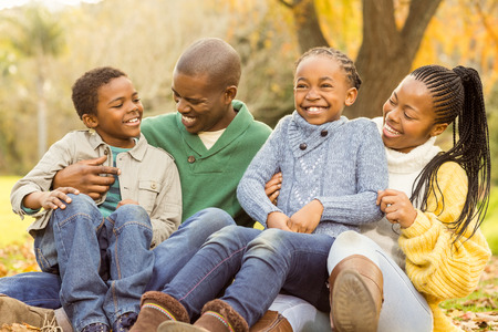 Portrait of a young family sitting in leaves on an autumns dayの写真素材
