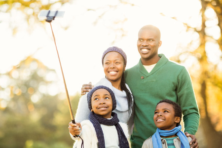 Young smiling family taking selfies on an autumns day