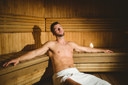 Man sitting inside a sauna at the spaの写真素材