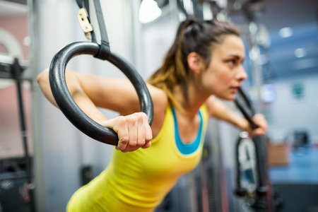 Smiling woman exercising her arms at the gymの写真素材