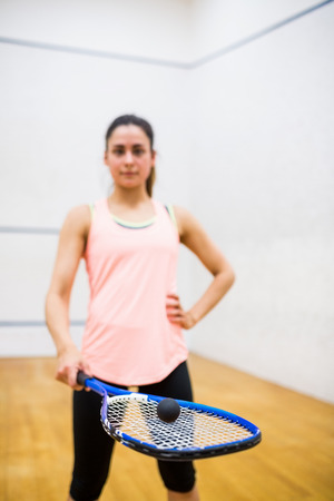 Woman balancing a ball on her racket in the squash courtの写真素材