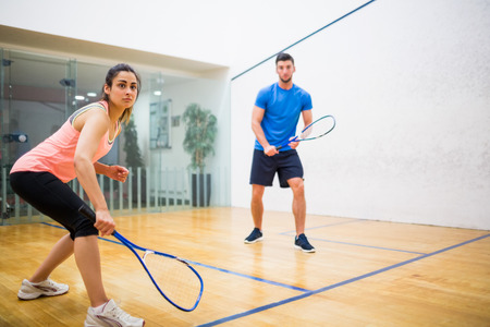 Couple play some squash together in the squash courtの写真素材