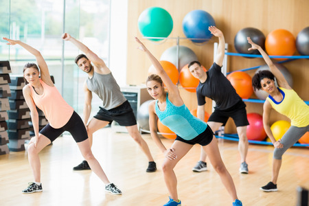 Fitness class exercising in the studio at the gym