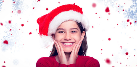 Festive little girl smiling at camera against snowflake patternの写真素材