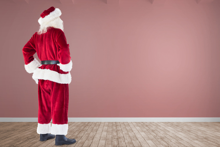 Santa with hands on hips against room with wooden floorの写真素材