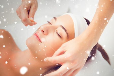 Snow against hands threading beautiful womans upper lipの写真素材