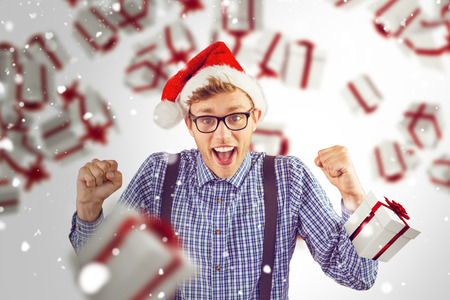 Geeky hipster wearing santa hat against snowの写真素材