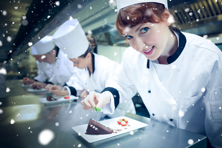 Snow against smiling chef garnishing dessert plateの写真素材