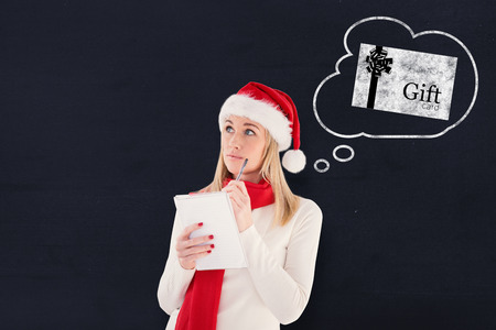 Festive blonde writing her christmas list against navy blueの写真素材