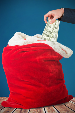 Hand holding hundred dollar bills against wooden planks backgroundの写真素材