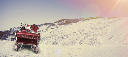 Santa flying his sleigh against snowy mountain under blue skyの写真素材