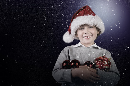 Festive boy smiling against snowの写真素材