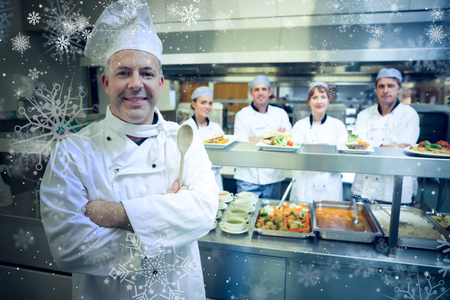 Snow against experienced head chef posing proudly in a modern kitchenの写真素材