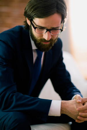 Businessman sitting on the couch at home in the living roomの写真素材
