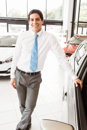 Man leaning on the door at new car showroomの写真素材