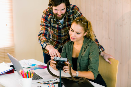 Creative team working at desk with laptop in casual officeの写真素材