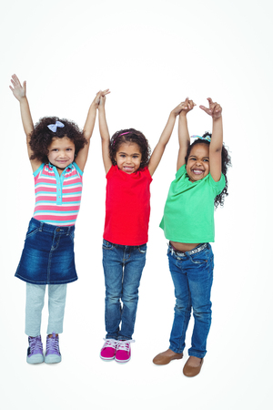 Three small girls standing together against a white backgroundの写真素材