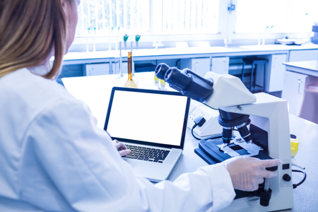 Scientist working with a microscope in laboratory at the universityの写真素材