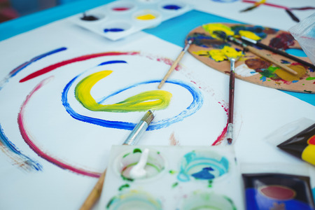 Happy kids enjoying arts and crafts painting at their desk