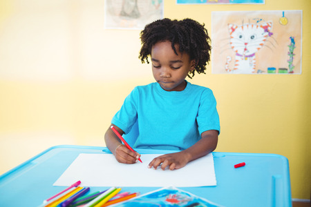 School kid drawing on a sheet in his roomの写真素材