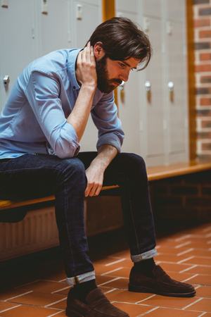 Hipster student feeling sad in hallway at the universityの写真素材