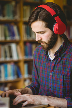 Hipster student studying in library at the universityの写真素材