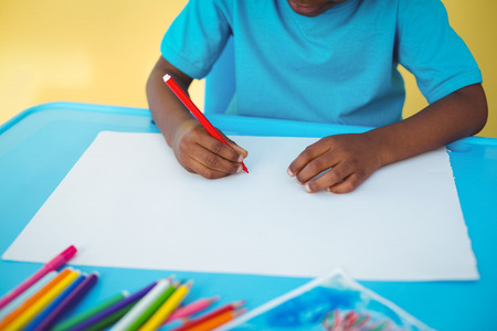 School kid drawing on a sheet in his room