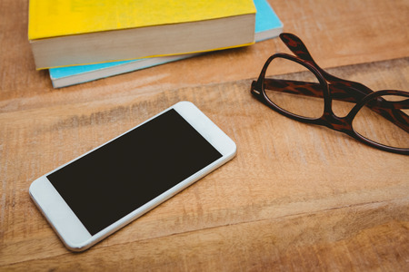 Close up view of smartphone and glasses on wood plankの写真素材