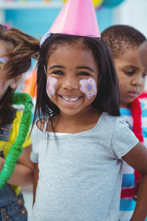 Happy girl with her face painted at the birthday partyの写真素材