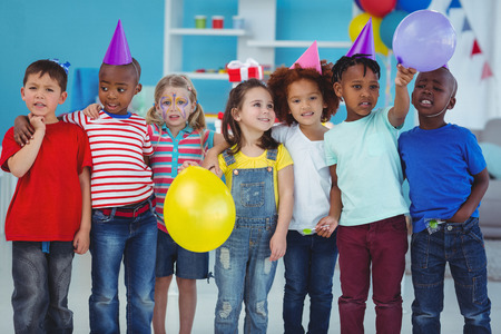 Happy kids enjoying a birthday party standing togetherの写真素材
