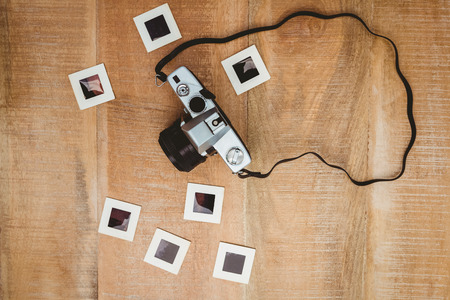 View of an old camera with photo slides on wood deskの写真素材