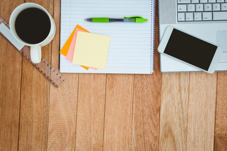 Above view of business desk with smartphone and laptopの写真素材